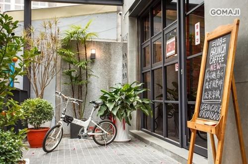 108 House Inn في تاى نان: دراجة متوقفة خارج مطعم مع لوحة
