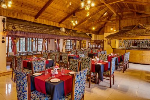 Un comedor con mesas y sillas en un edificio. en Sterling Gangtok Orange Village, en Gangtok