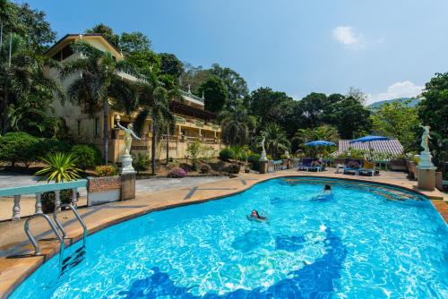 a pool at a hotel with people swimming in it at Baan Karon Hill Phuket Resort in Karon Beach