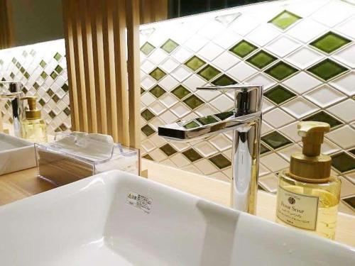 lavabo en el baño con una botella de perfume en una encimera en Cabin House Yado Fujinomiya en Fujinomiya