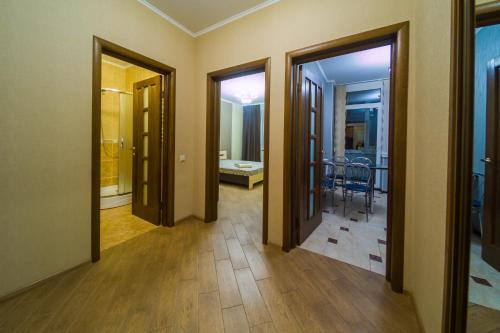 um corredor com portas e um quarto com uma mesa em Kvartirkoff na Bogatirskaya 6a, 2 floor em Kiev