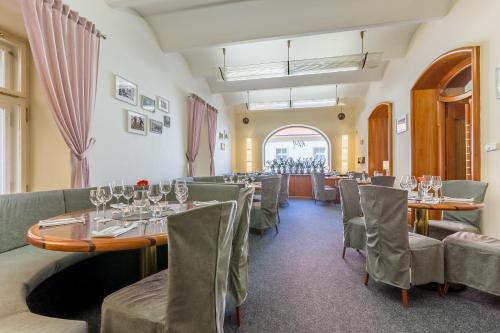 a restaurant with tables and chairs and a window at Hotel U Rytíře in Mělník