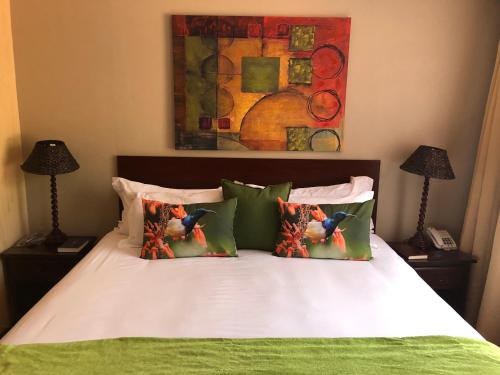 a bed with two pillows and a painting on the wall at 314 on Clark Guest House in Pretoria