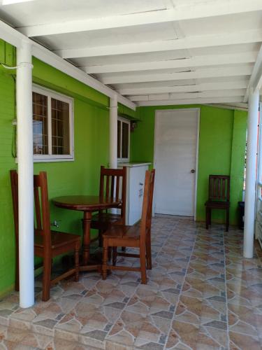 a dining room with green walls and a table and chairs at A.C. Asistin Transient House in Baguio