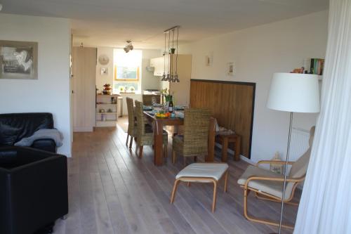 a living room and dining room with a table and chairs at Perle am Ijsselmeer mit eigenem Tretboot in Medemblik