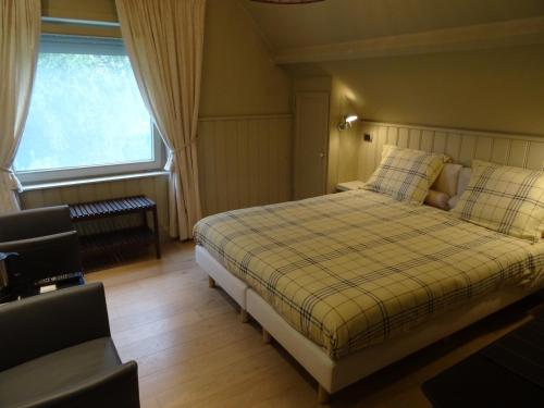 een slaapkamer met een bed en een raam bij B & B DE SERAFIJN in Lochristi
