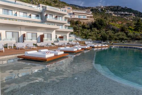 a swimming pool with lounge chairs and a hotel at Messinian Icon Hotel & Suites in Kalamata