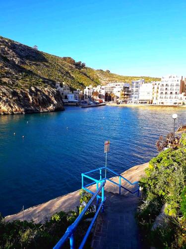 a blue dock in the middle of a body of water at Moby Dick Xlendi Holiday Apartments in Xlendi