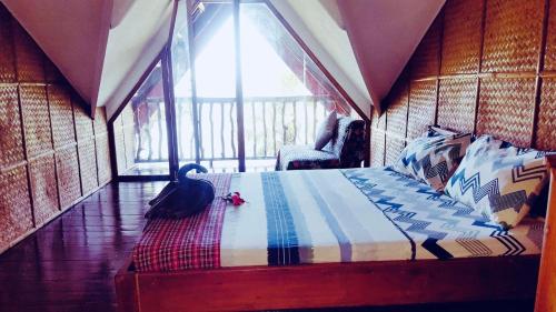 a bedroom with a bed with a bird sitting on the floor at White Beach Front and Cottages in Buruanga