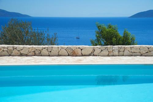 a swimming pool with the ocean in the background at Villa Kandia in Ayia Evfimia