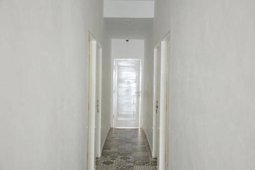 a hallway with white walls and a white door at RedDoorz Plus near UNIMED Medan in Medan