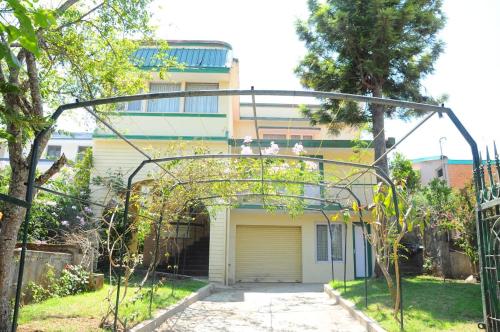 a building with an archway in front of a house at Green Woods Homestay in Kodaikānāl