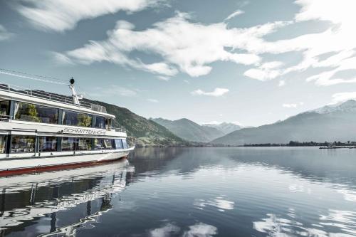 a boat on a lake with mountains in the background at Apartment 5 Peaks in Zell am See