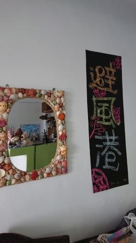 a mirror on a wall with a picture of a kitchen at Haven Seaview Homestay in Lanyu