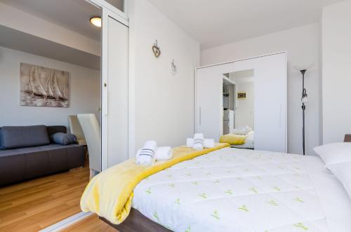 a white bedroom with a large bed and a couch at Apartments Lorena Mljet in Pomena