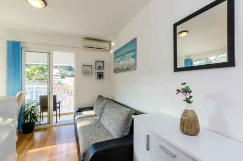 a living room with a couch and a mirror at Apartments Lorena Mljet in Pomena