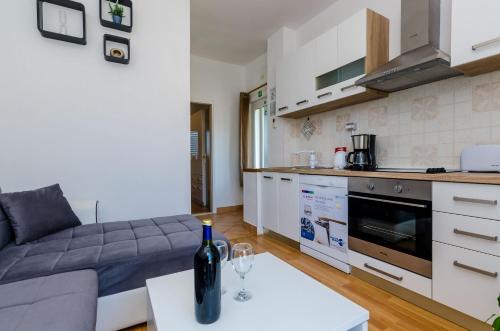 a living room with a couch and a wine bottle on a table at Apartments Lorena Mljet in Pomena