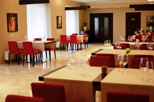 a restaurant with tables and red chairs and wine glasses at Pushcha Congress Hotel in Kyiv