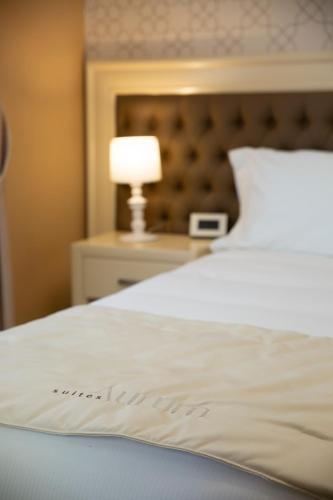 a close up of a white bed with a lamp at Aurum Suites in Pescara