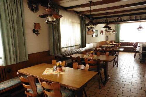 a restaurant with wooden tables and chairs and windows at Gasthof _ Pension _ Drei Linden in Pegnitz