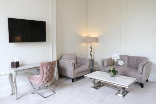 a living room with two chairs and a tv at Winstanley House in Leicester