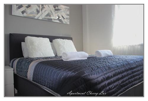 a bedroom with a bed with two towels on it at Apartment Cherry Lux in Zrenjanin