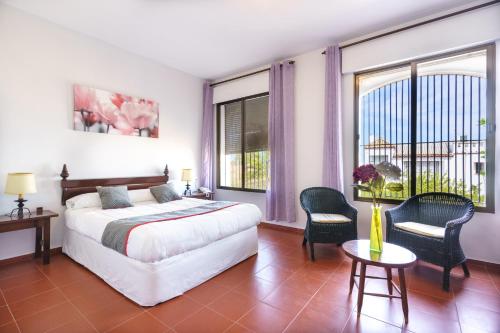 1 dormitorio con 1 cama, mesa y sillas en Venta del Alto Hotel las Cumbres by Vivere Stays, en El Garrobo