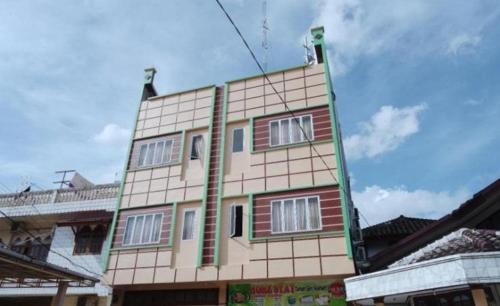 a tall building with windows on top of it at Guest House Taman Sari Syariah in Parit