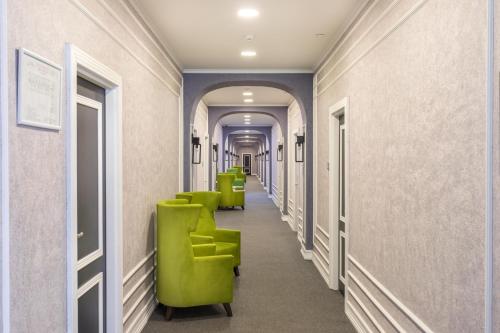 a row of green chairs in a hallway at Dondar Hotel Formula 1 View in Baku