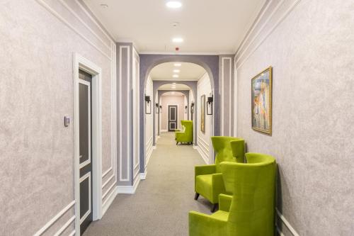 a corridor with green chairs in a hallway at Dondar Hotel Formula 1 View in Baku