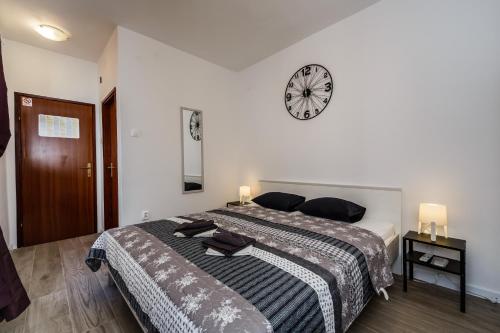 a bedroom with a large bed with a clock on the wall at Room Mar in Vis