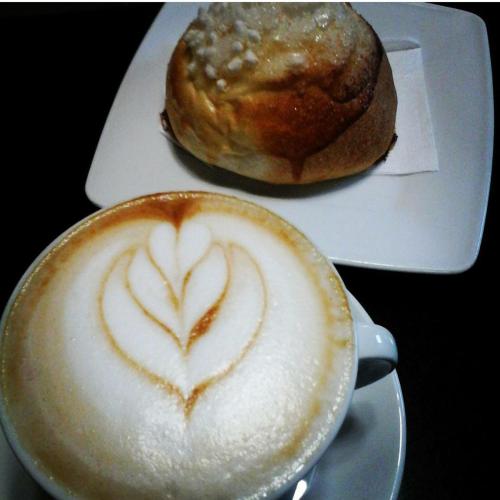 a cup of coffee and a pastry on a plate at B&B MONTEBELLO in Trani