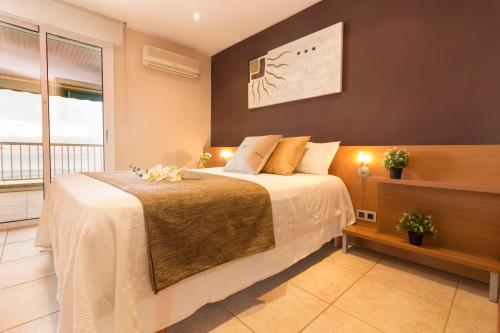 a bedroom with a bed and a large window at Homes & Go Bell Reco Deluxe I in La Pineda