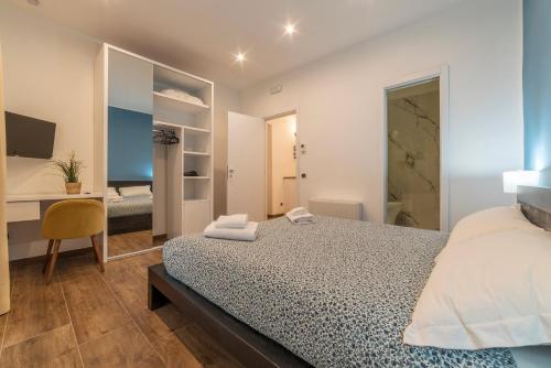 een slaapkamer met een bed, een bureau en een spiegel bij Guest House Sallustiano in Rome