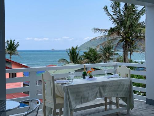a table on a balcony with a view of the ocean at Isaguirre's Pension House in Baler