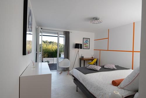 a bedroom with a bed and a table and a desk at Mise en Scène in Aumelas