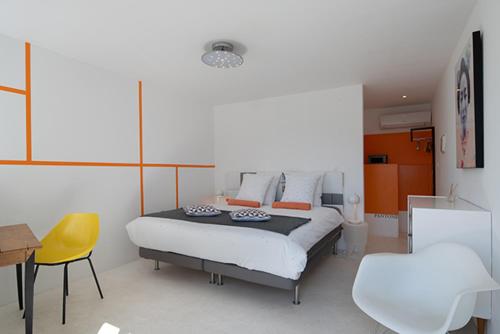 a bedroom with a bed and a table and chairs at Mise en Scène in Aumelas