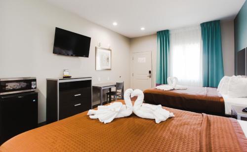 two swans sitting on a bed in a hotel room at Express Inn - Spring in Spring