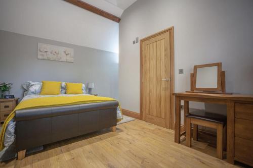 um quarto com uma cama, uma secretária e um espelho em Little Oak by RentMyHouse em Hereford