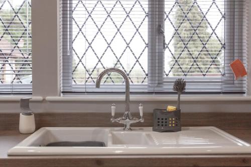 um lavatório numa cozinha com uma janela em Little Oak by RentMyHouse em Hereford