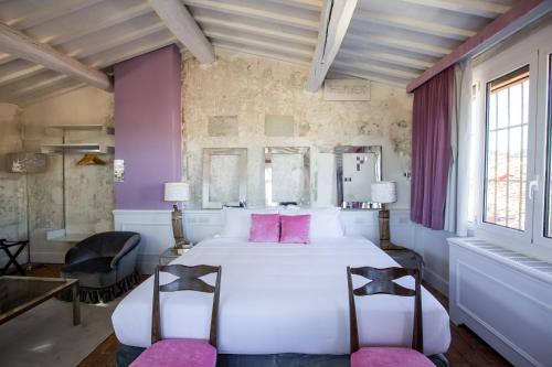 - une chambre avec un grand lit blanc et des oreillers roses dans l'établissement Oltrarno Splendid, à Florence