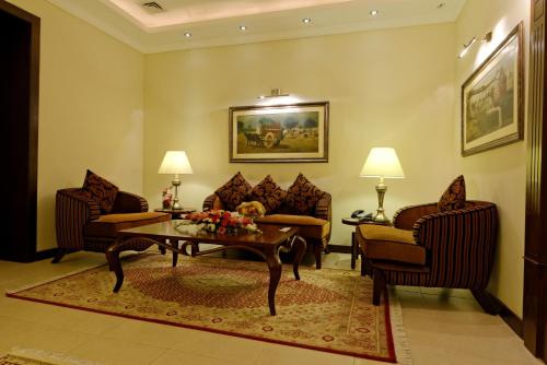 a living room with couches and a coffee table at Faletti's Hotel Lahore in Lahore