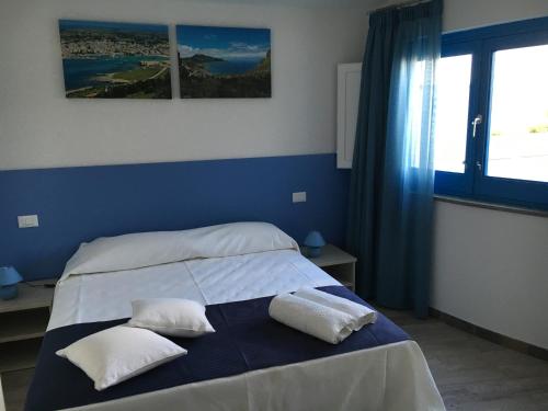 a bedroom with a bed with two pillows on it at Le case di Palma in San Vito lo Capo