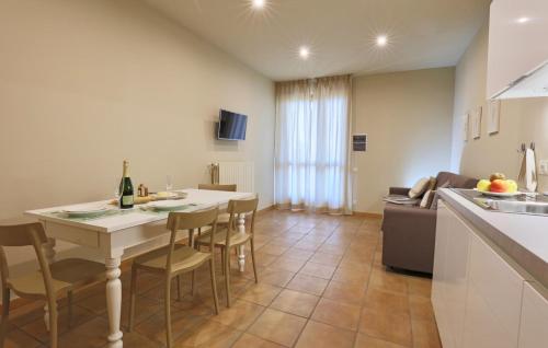 a kitchen and living room with a table and chairs at LE SETTE VIE HOLIDAY HOMES in Monforte dʼAlba