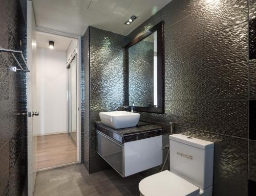 a bathroom with a sink and a toilet and a mirror at PJ8 Service Suites by Airhost in Petaling Jaya