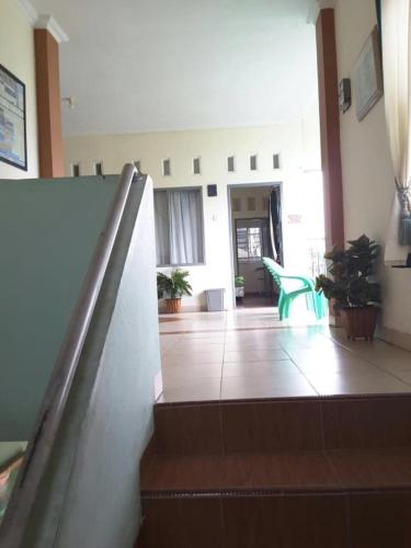 a hallway of a building with stairs and plants at Penginapan Syariah in Parit
