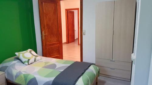 1 dormitorio con cama y pared verde en Casa Ponet, en Valencia de Aneu
