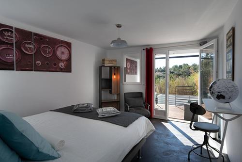 Aumelas的住宿－麥斯塞恩旅館，卧室配有床、椅子和窗户。