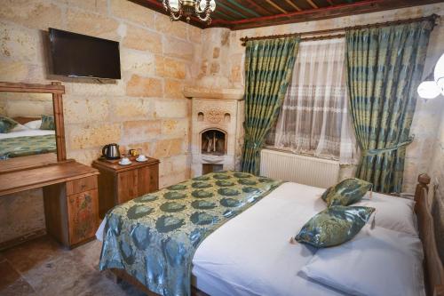 a bedroom with a bed and a tv and a fireplace at Cappadocia sightseeing Hotel in Göreme
