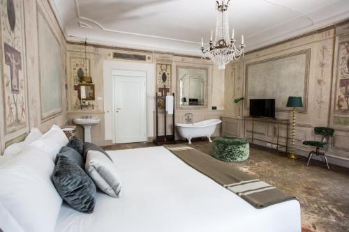 - une chambre avec un grand lit blanc et une baignoire dans l'établissement Oltrarno Splendid, à Florence